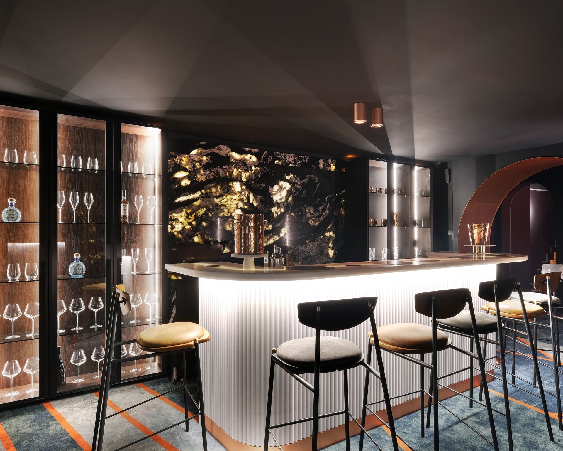 Comptoir de bar blanc en marbre Bianco Nieve et habillage blanc cannelé, panneau mural noir veiné d'or
