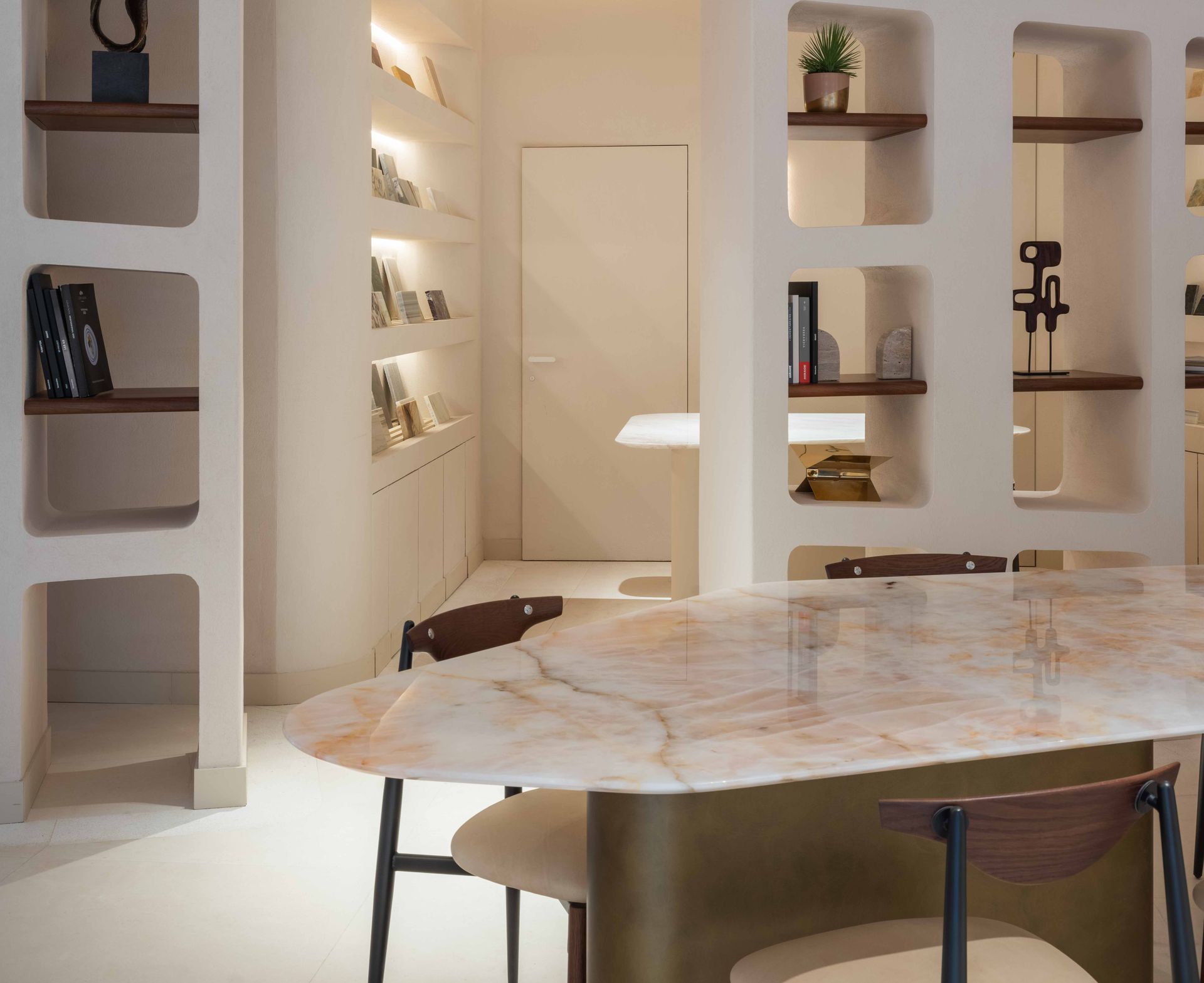 Table de réunion à plateau blanc veiné de rose en quartzite Cristal Pink et socle laiton, dans un espace de travail