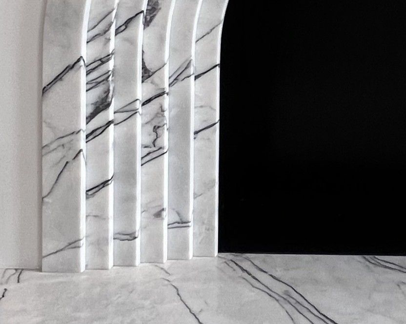 Détail d'un habillage de cheminée blanc en marbre Lilac, en arche cannelée