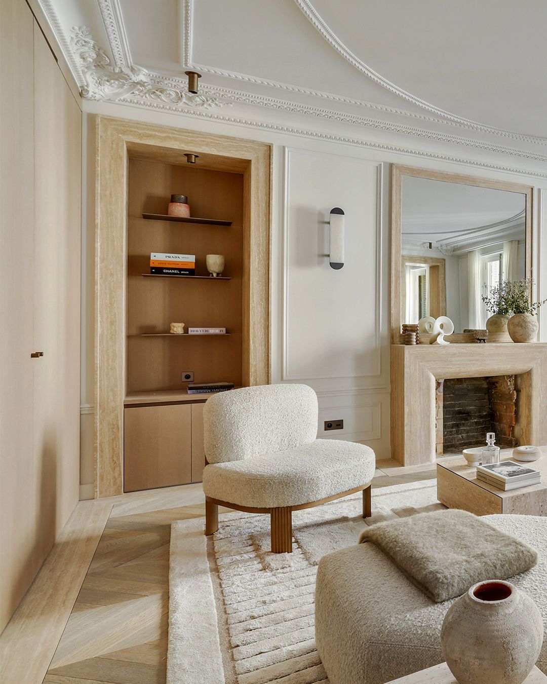 Cheminée habillée de travertin beige vue depuis un salon crème