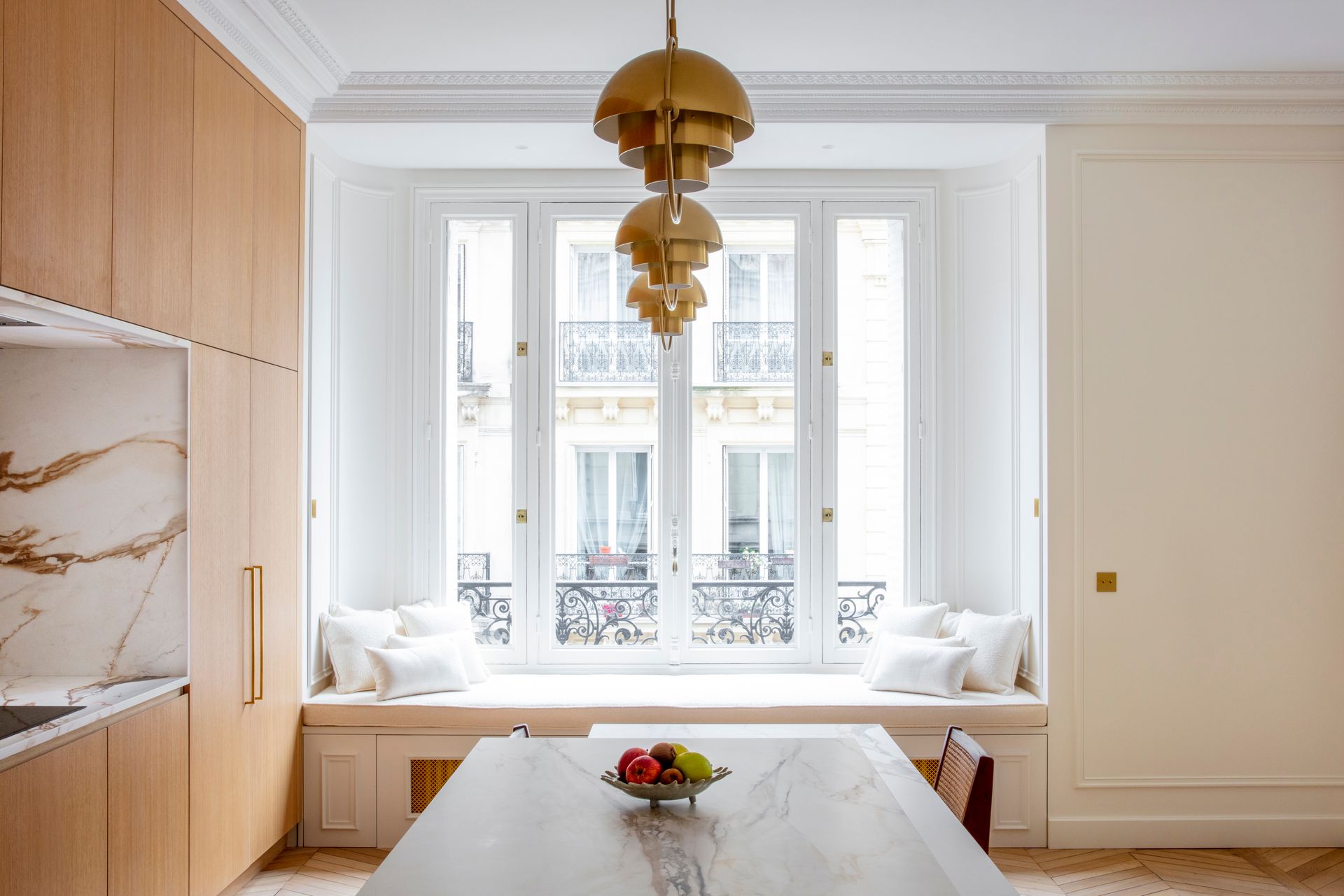 Vue d'ensemble d'une cuisine à façades bois clair et plan de travail blanc en céramique MStone Antique Oro