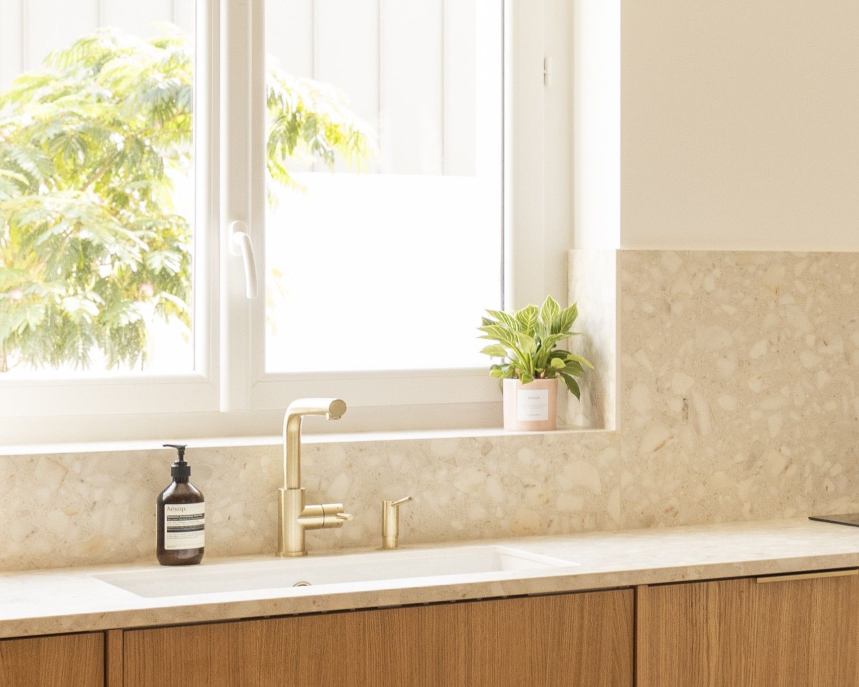 Évier taillé dans un plan de travail beige en céramique Neolith The Size Retrostone, cuisine à façades bois clair, Karen Tinka