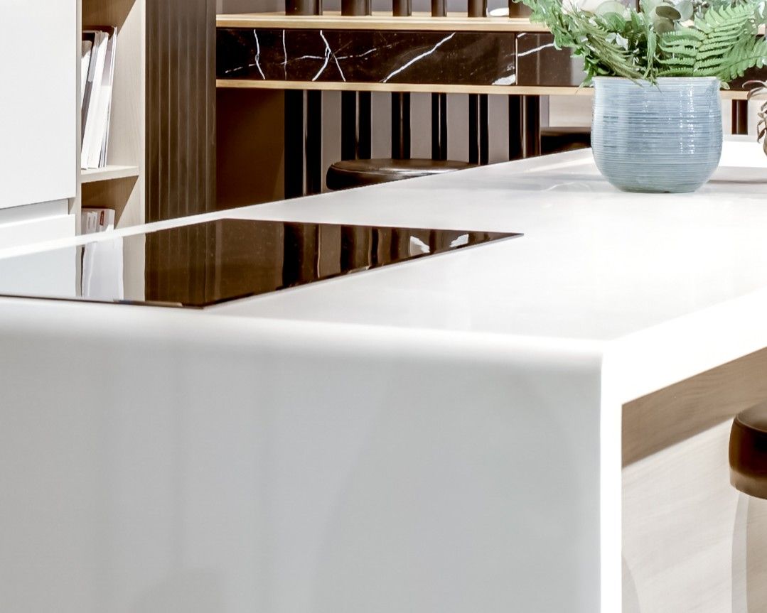 Angle d'un plan de travail blanc en Corian Designer White, cuisine à façades blanches laquées