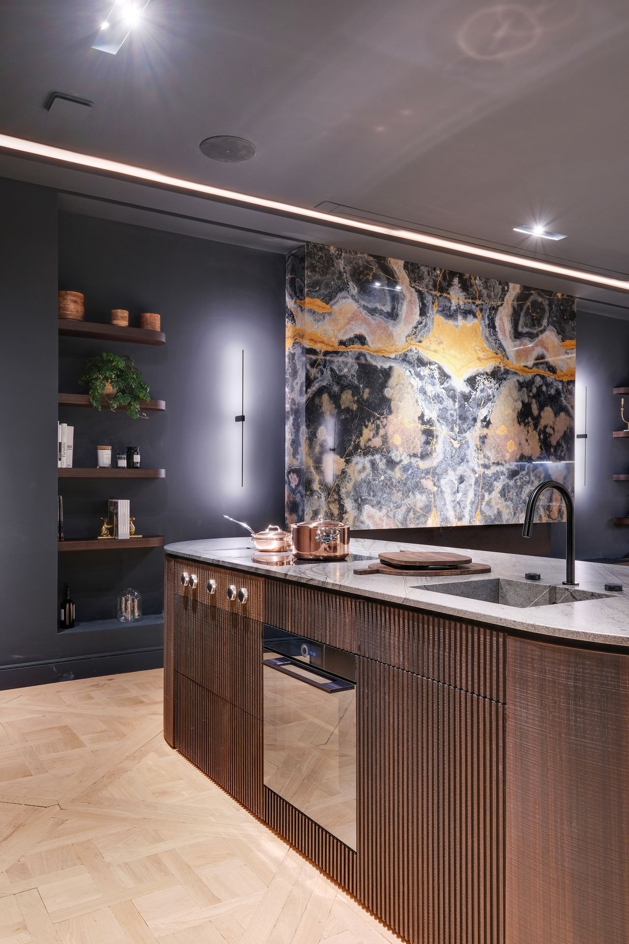 Cuisine à façades bois foncé cannelé et plan de travail gris en quartzite Black Tempest, panneau mural noir veiné d'or