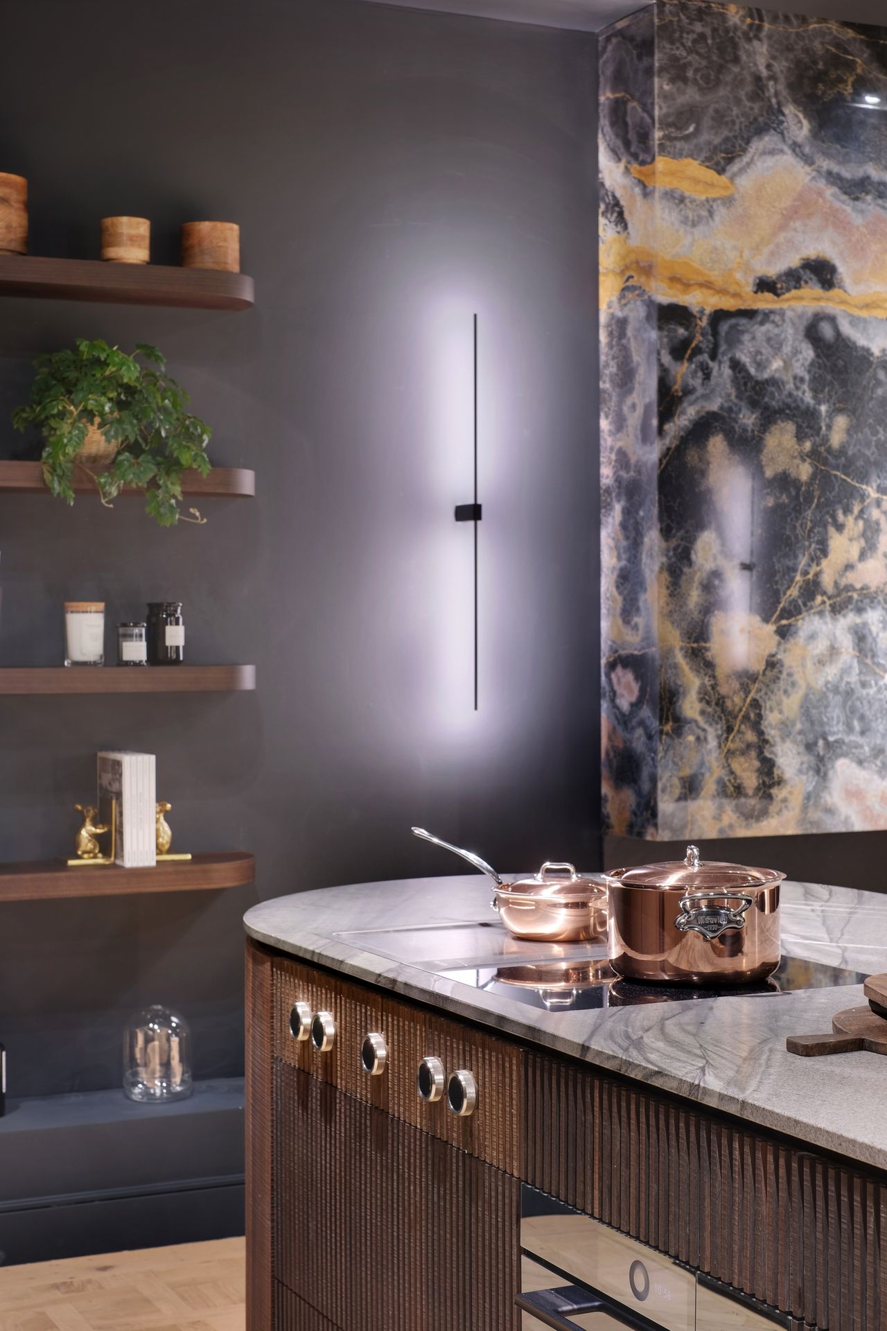 Angle d'un plan de travail gris en quartzite Black Tempest, cuisine à façades bois foncé cannelé