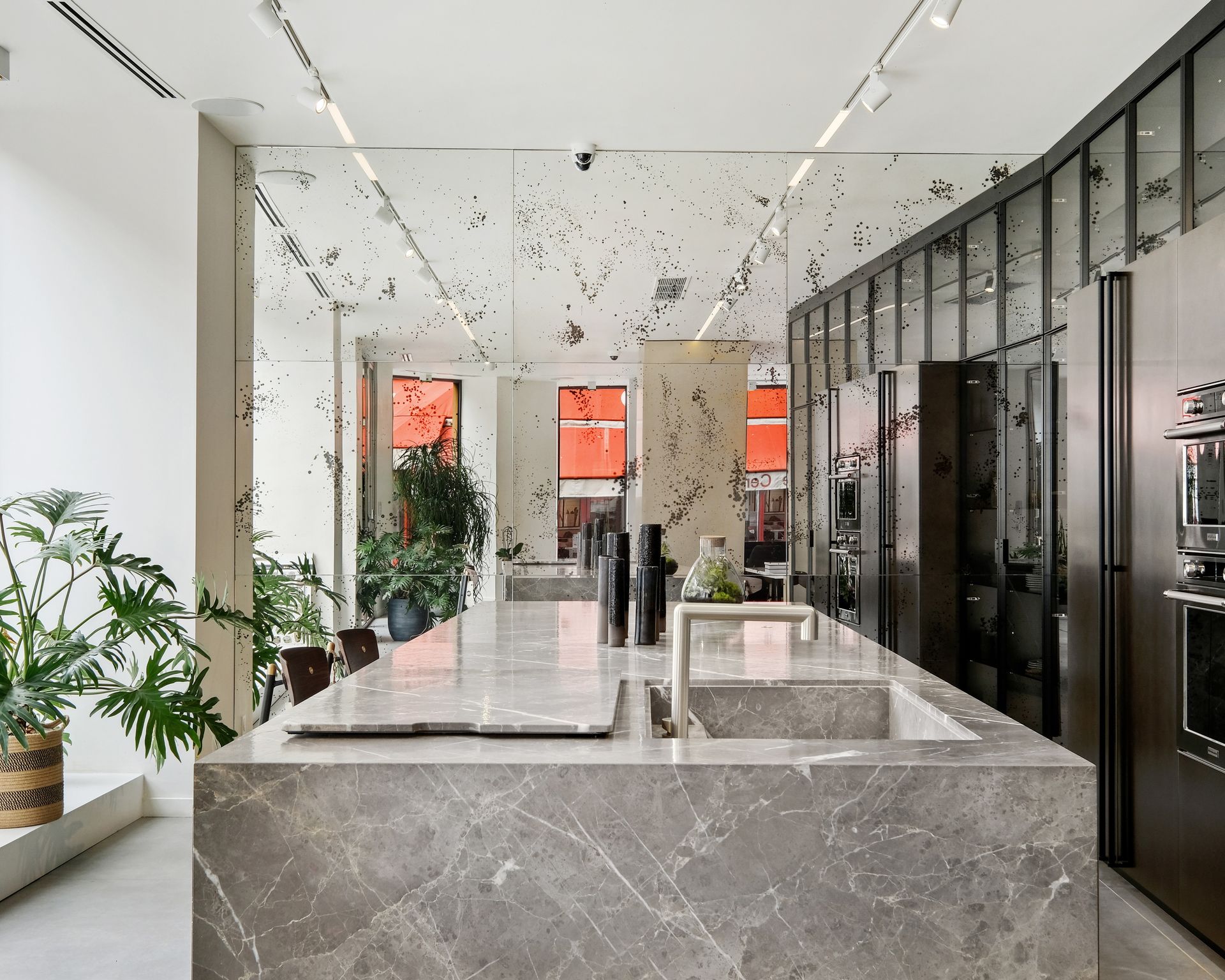 Plan de travail gris en marbre Grigio Collemandina sur toute la longueur d'un îlot de showroom