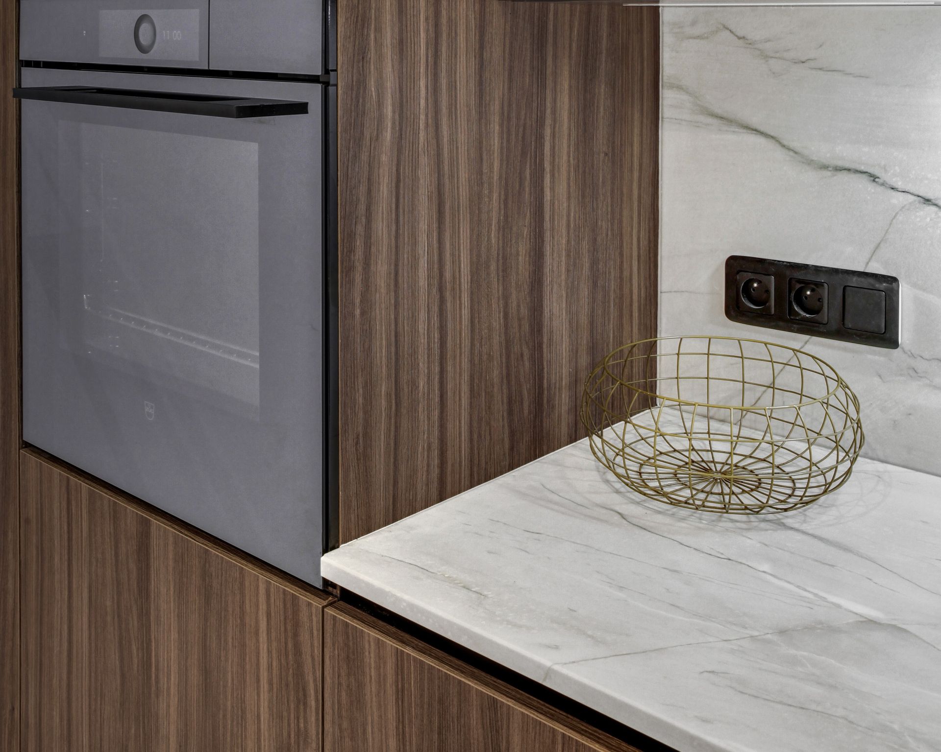 Angle d'un plan de travail blanc en quartzite Mont Blanc, cuisine à façades bois foncé