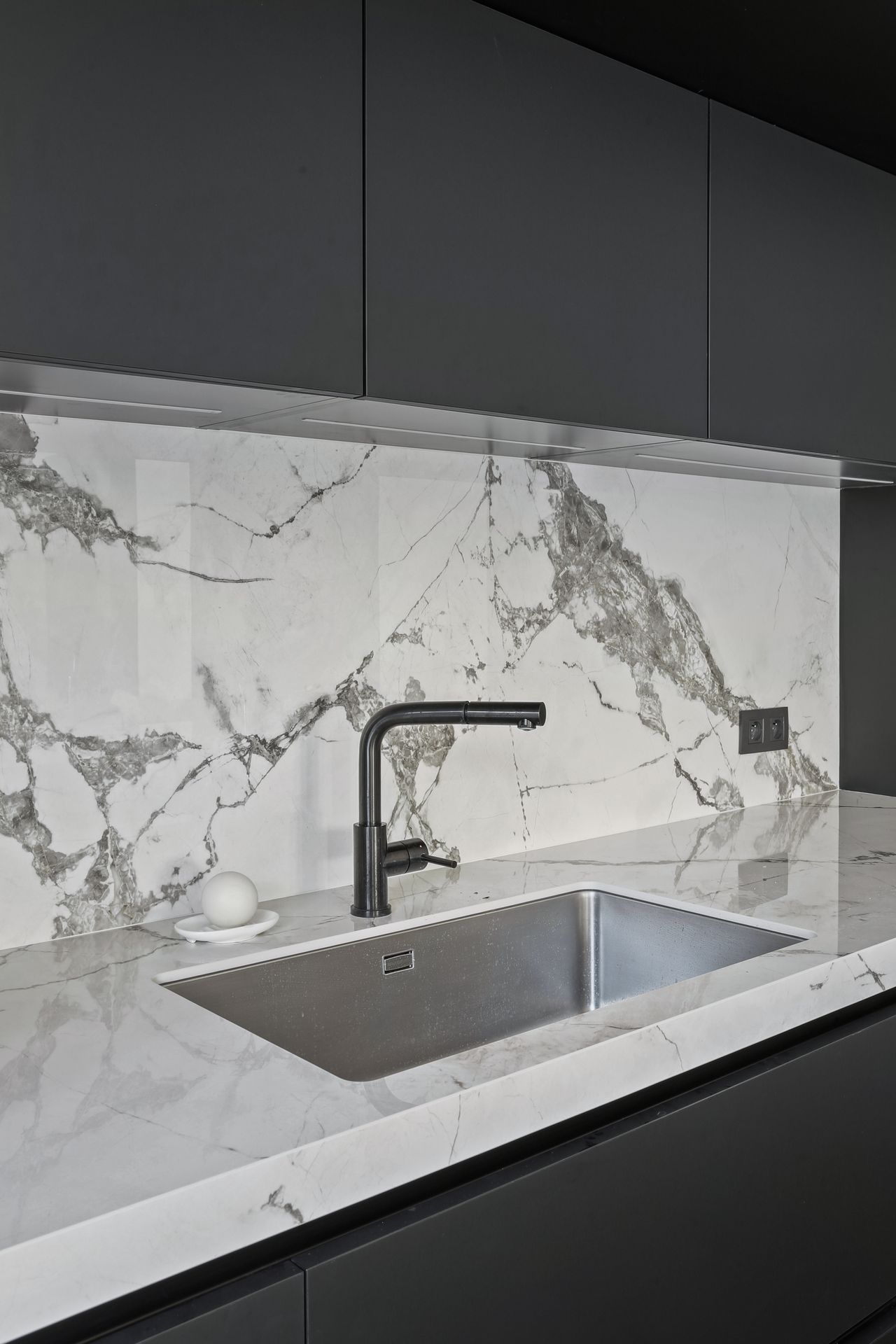 Évier taillé dans un plan de travail blanc en céramique Dekton Aura 22, cuisine à façades noires