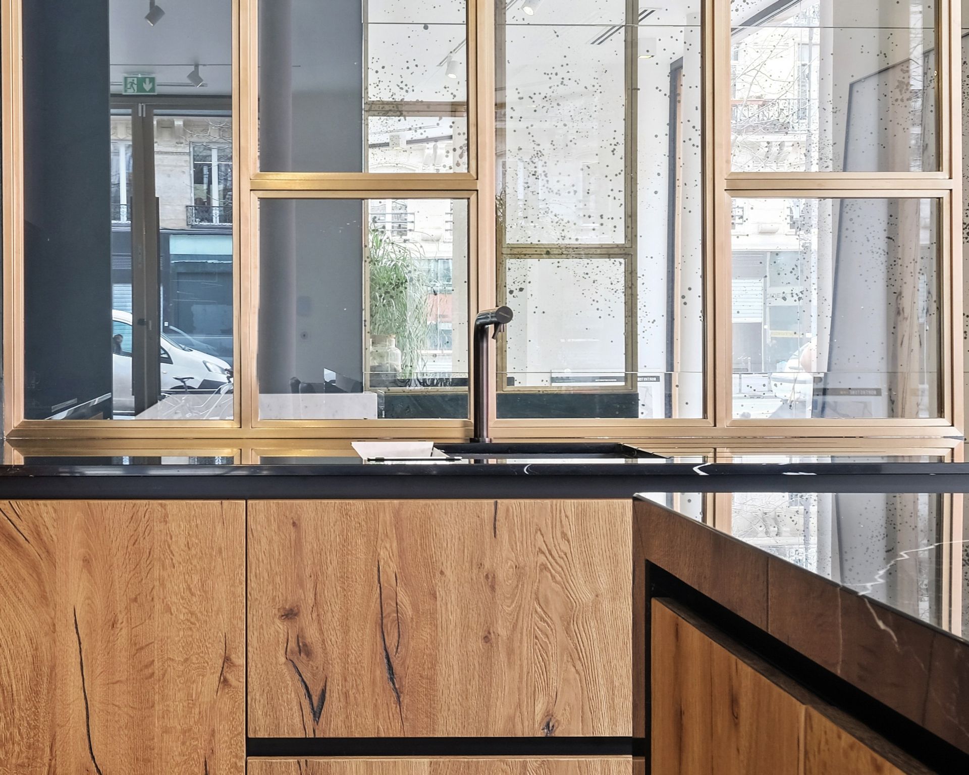 Angle d'un plan de travail noir en quartz Silestone Eternal Marquina, cuisine à façades bois clair