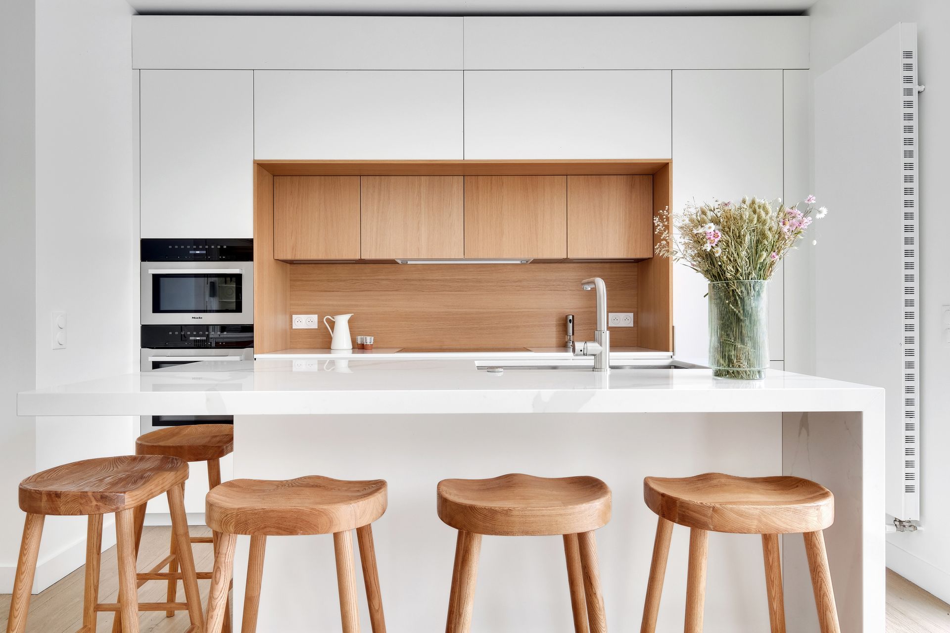 Cuisine à façades blanches et bois clair, plan de travail blanc en quartz Silestone Calacatta Gold