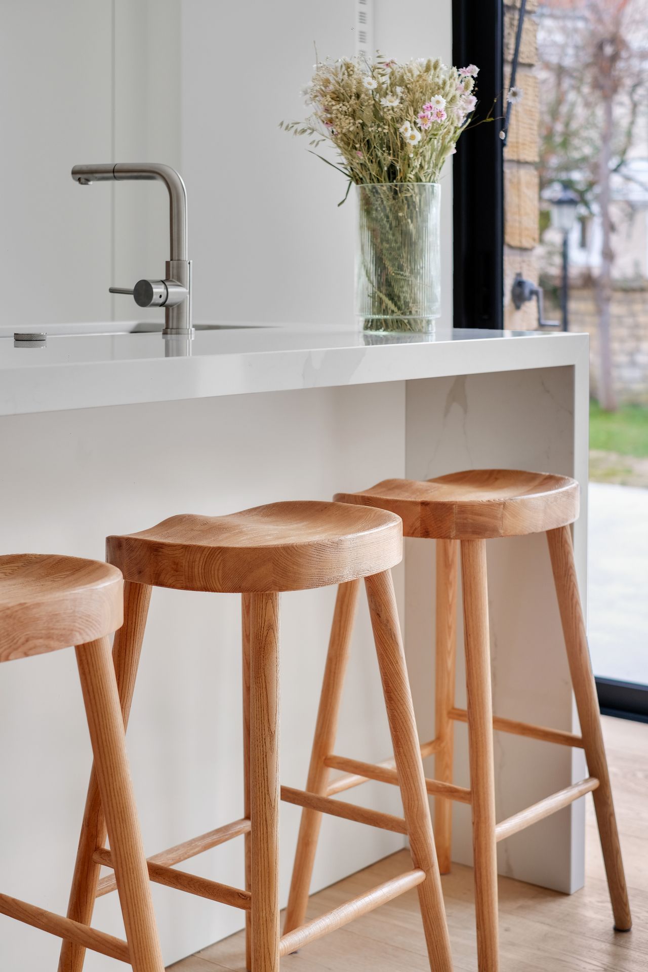 Angle d'un plan de travail blanc en quartz Silestone Calacatta Gold, cuisine à façades blanches et bois clair