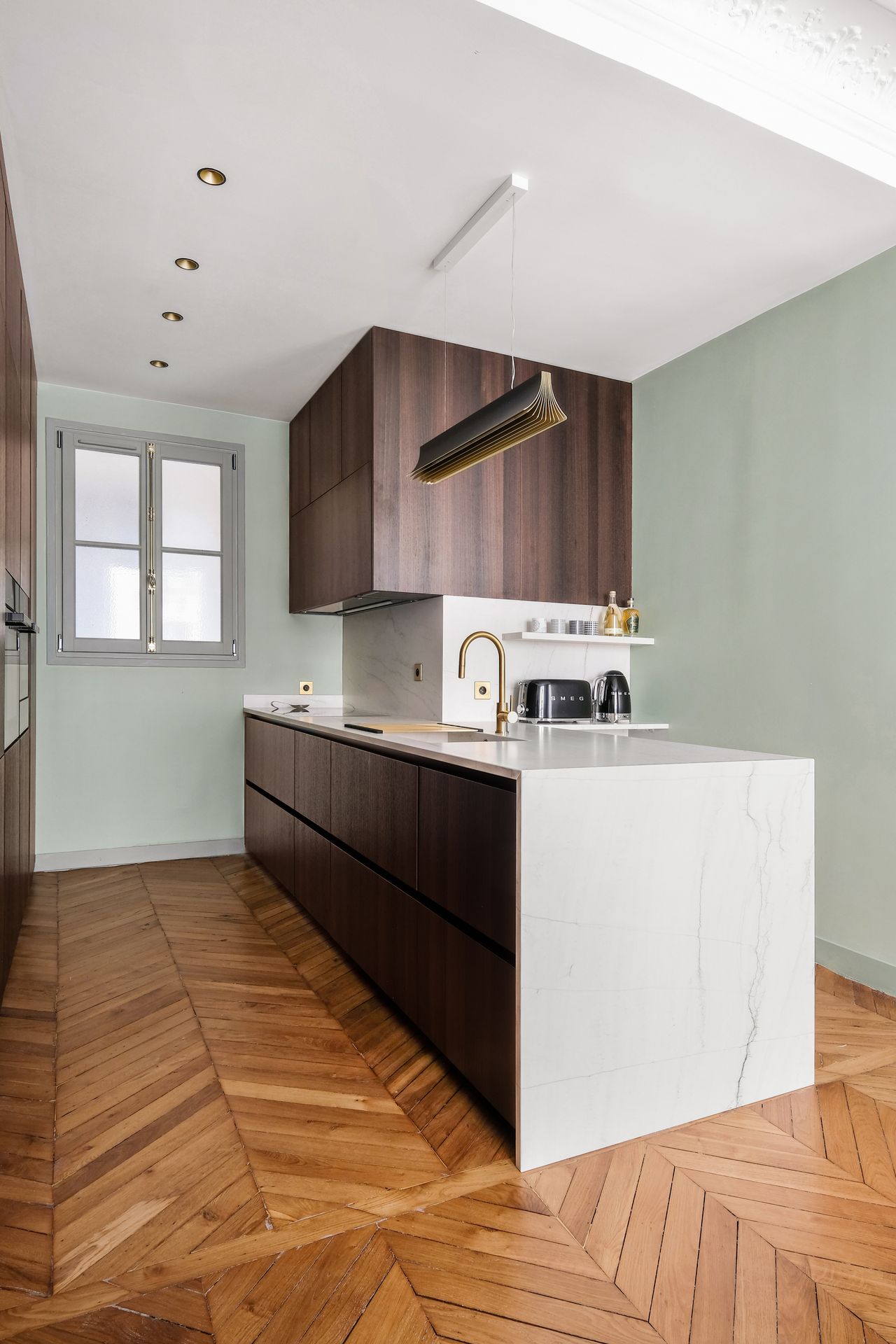 Vue d'ensemble d'une cuisine à façades bois foncé et plan de travail blanc en céramique Neolith The Size Mont Blanc