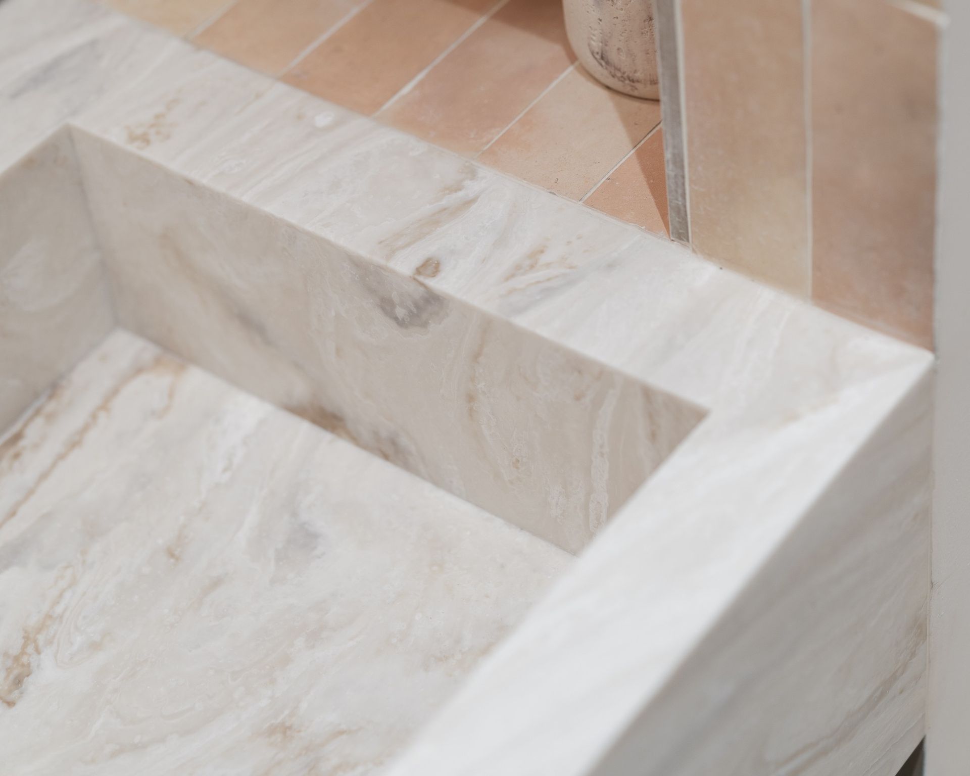 Gros plan du Corian Duna Prima crème dans une salle de bains à meuble bois foncé, Atelier Philibert