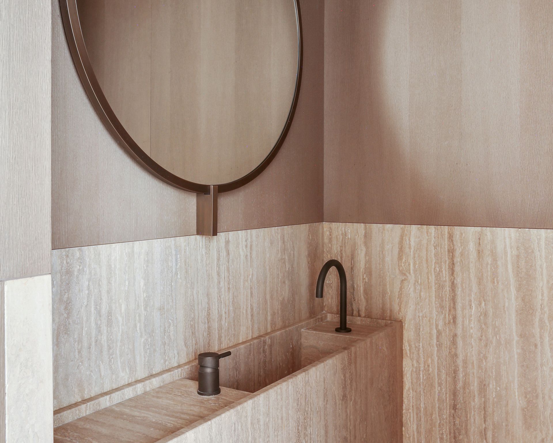 Gros plan du marbre Travertino Classique beige dans une salle de bains à meuble bois clair
