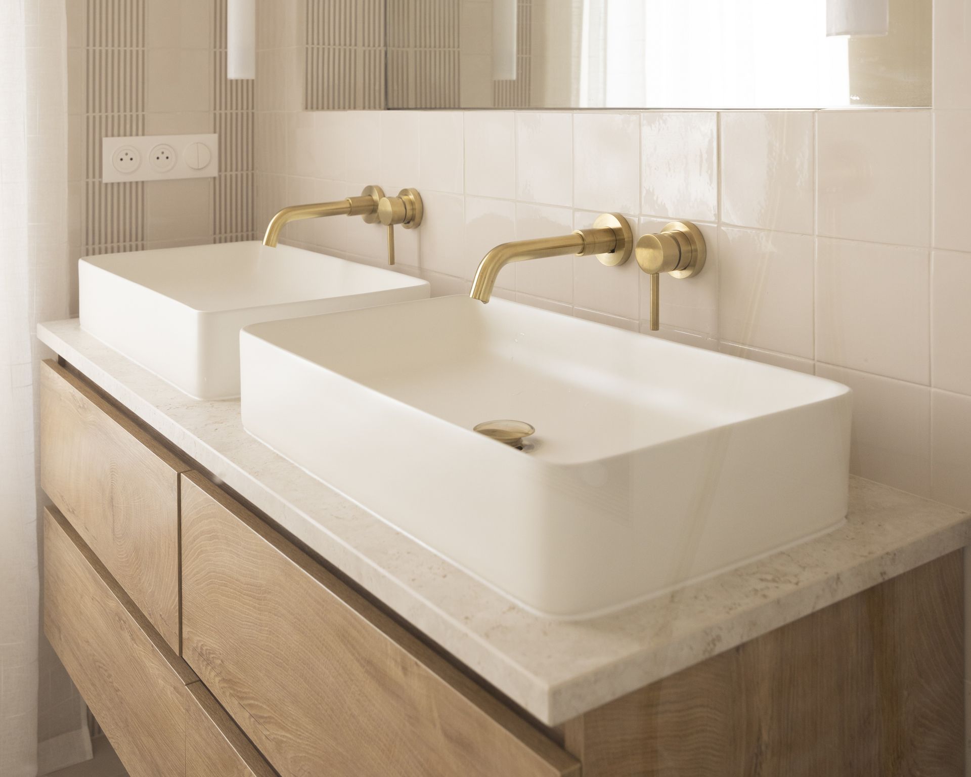 Plan de double vasque beige en pierre naturelle sur un meuble bois clair, Karen Tinka