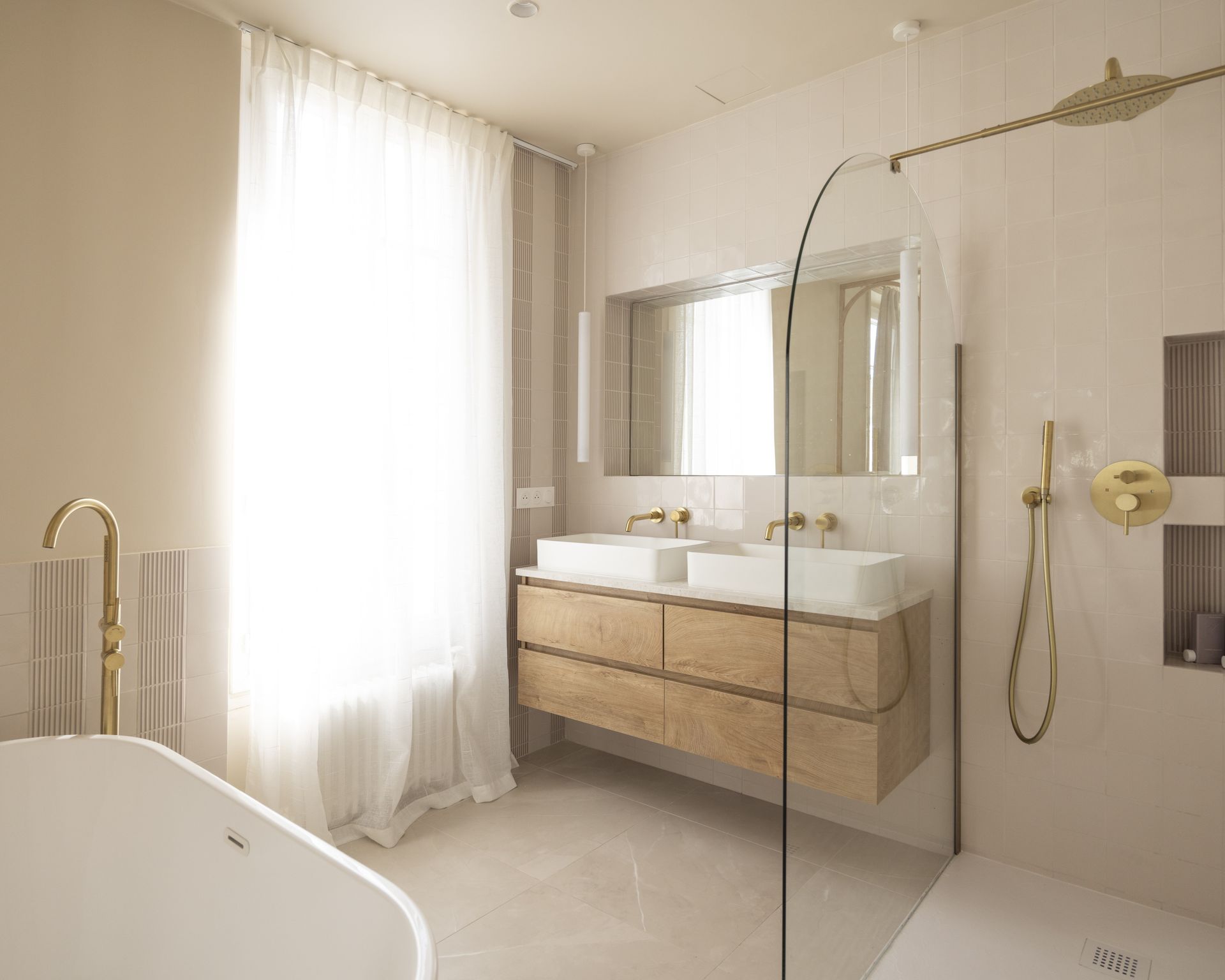 Salle de bains à meuble bois clair et plan de vasque beige en pierre naturelle, Karen Tinka