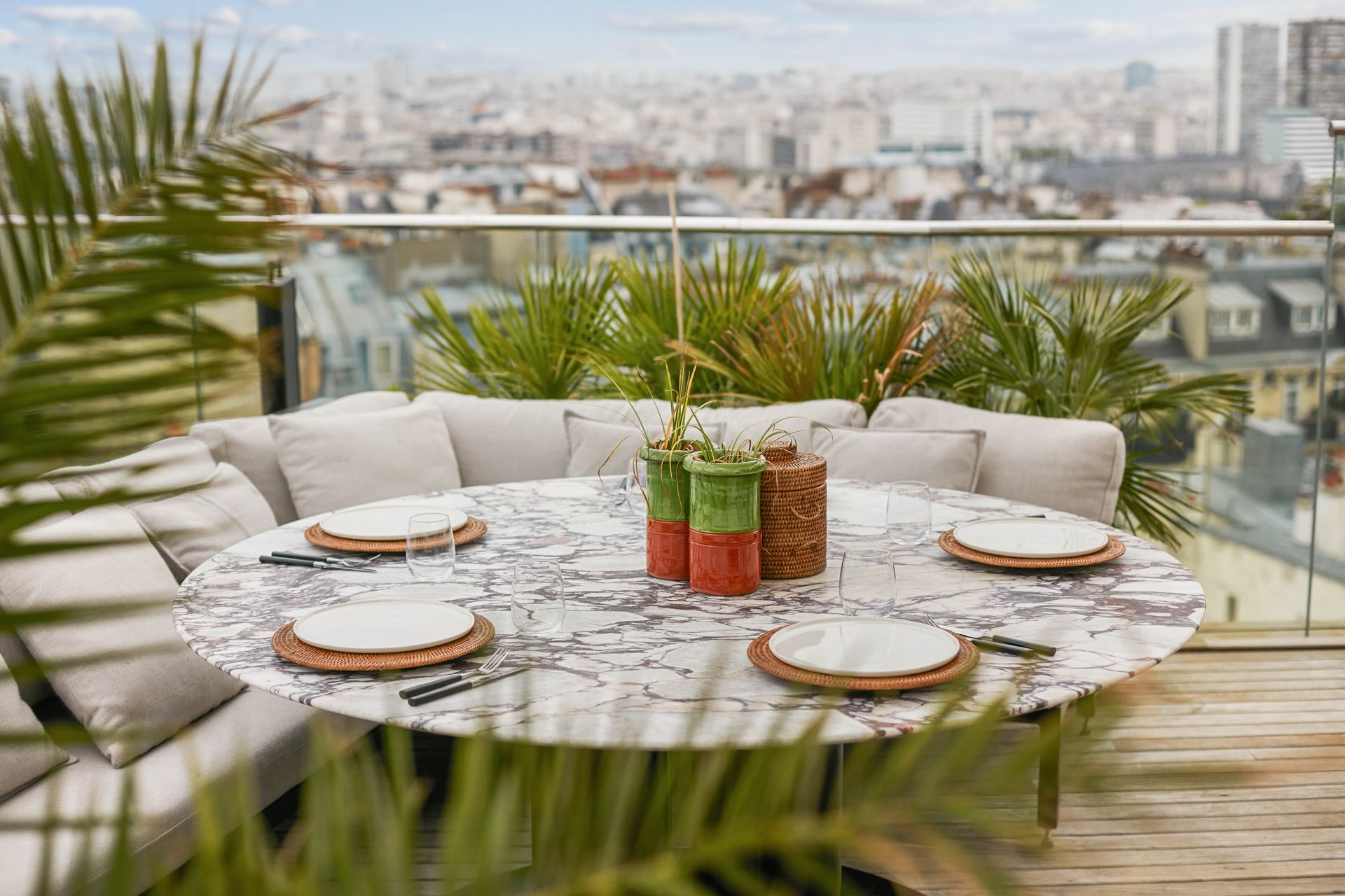 Table ronde à plateau blanc en marbre Calacatta Viola et socle noir, sur une terrasse
