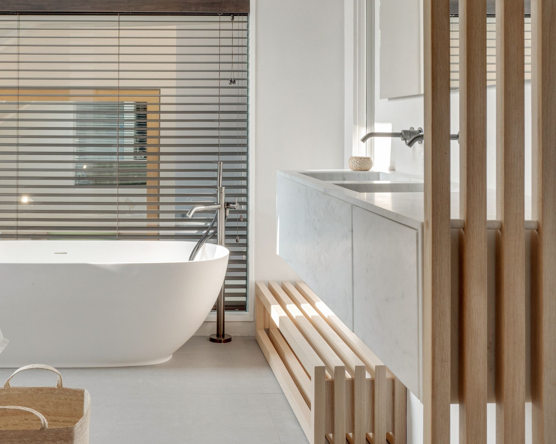 Salle de bains à meuble entièrement habillé de marbre Blanc Carrara, claustra en bois clair