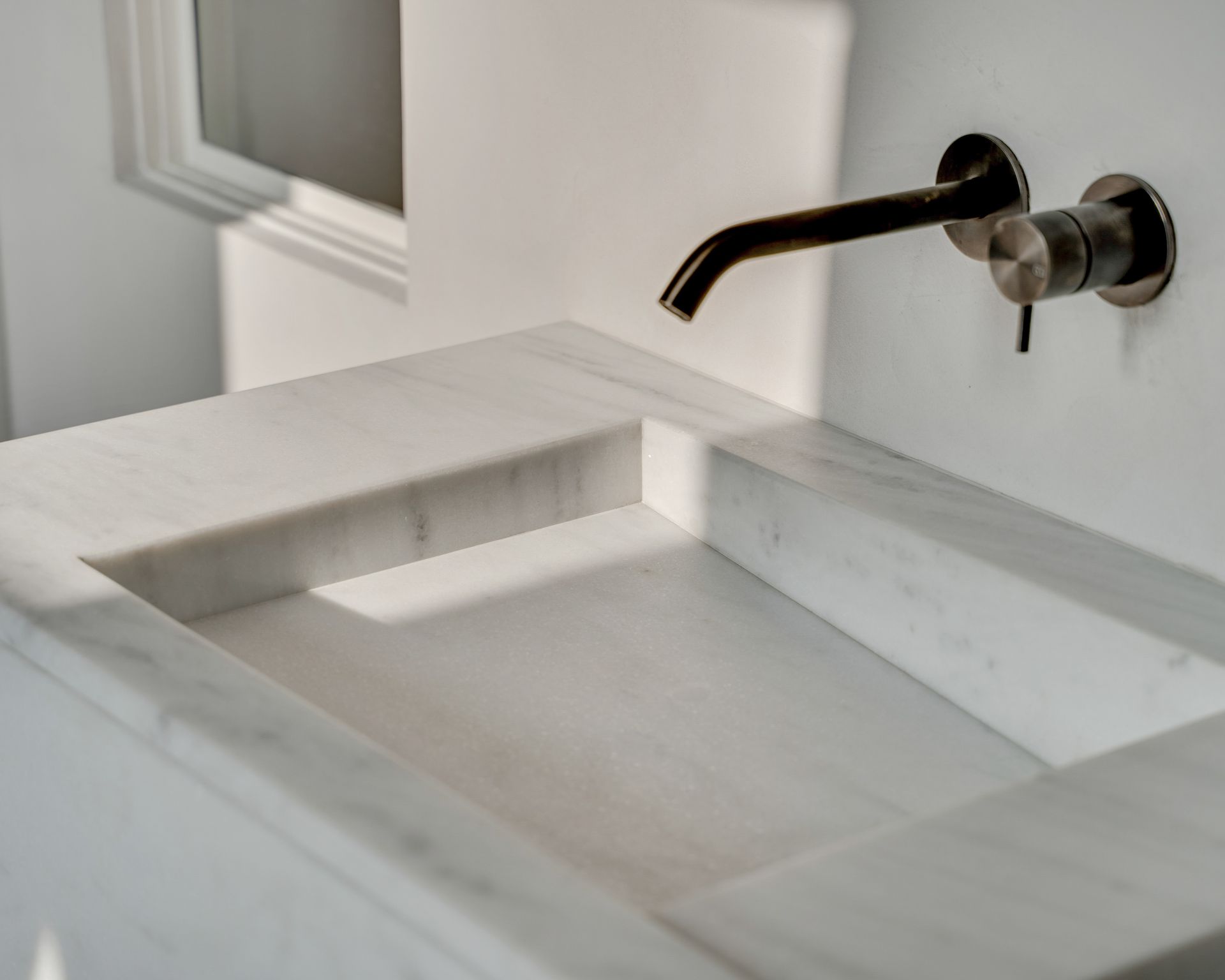 Plan de vasque blanc en marbre Blanc Carrara sur un meuble habillé du même marbre