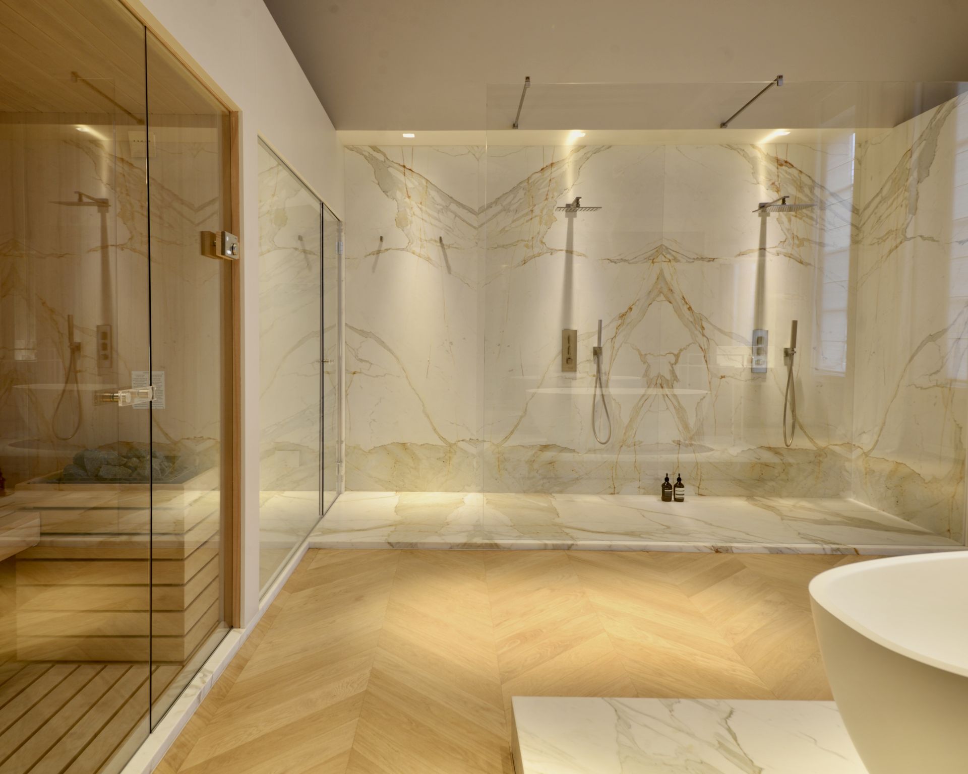 Douche habillée de marbre Calacatta Gold blanc dans une salle de bains aux murs blancs