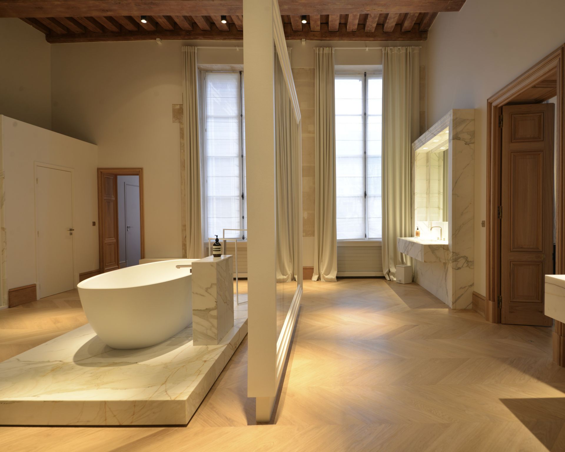 Baignoire habillée de marbre Calacatta Gold blanc dans une salle de bains aux murs blancs