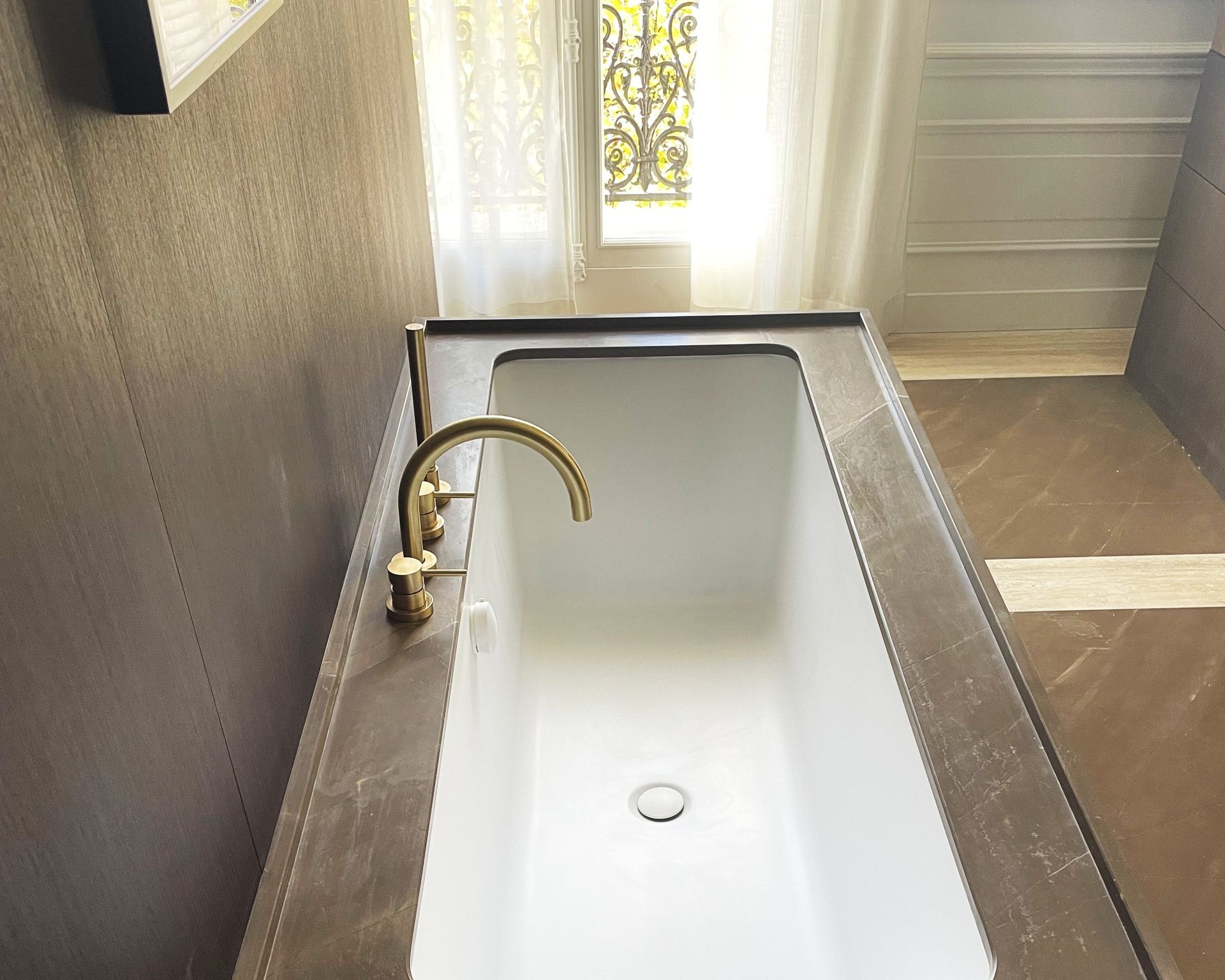 Baignoire habillée de marbre Pietra Grey gris brun, salle de bains à meuble bois foncé