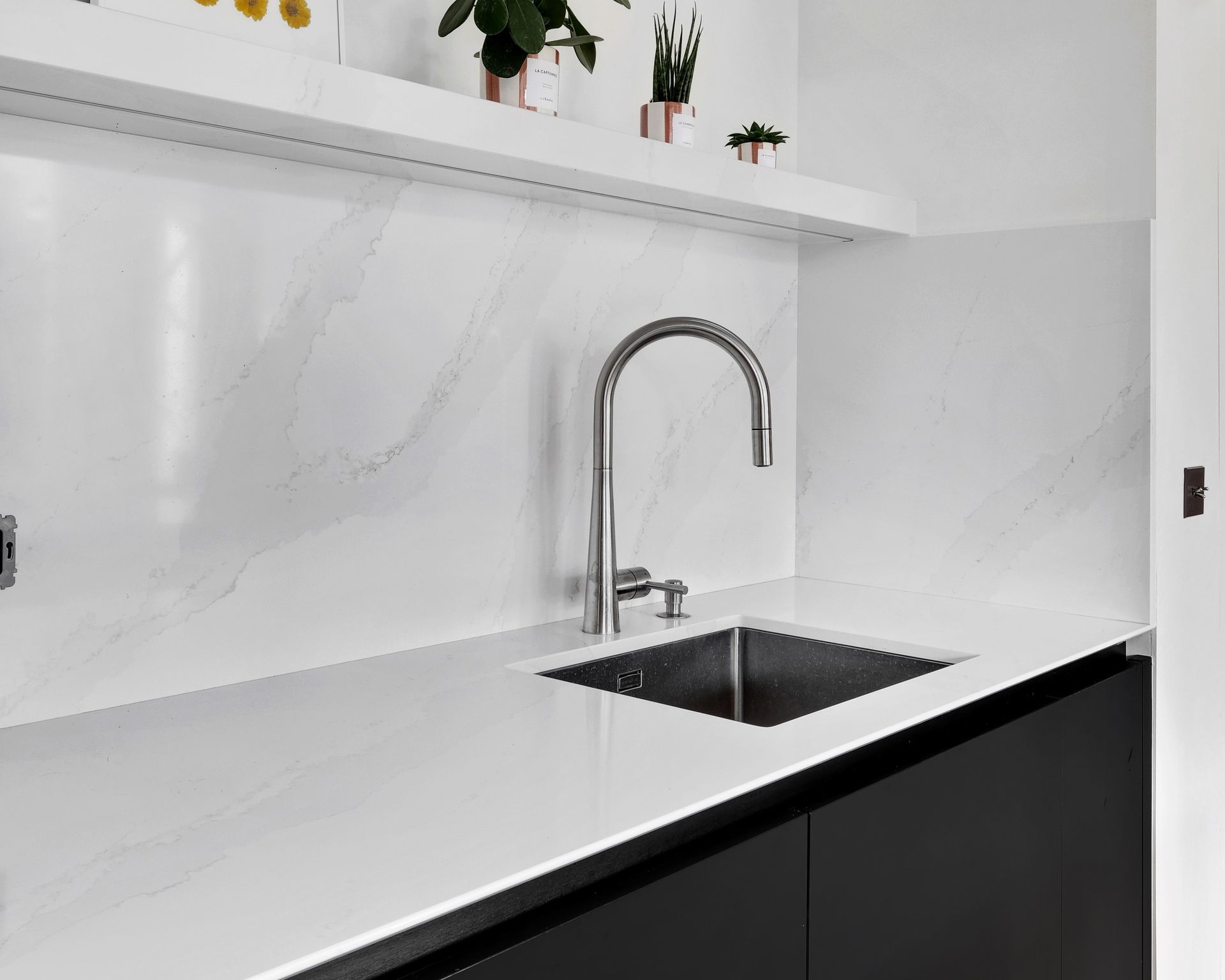 Évier taillé dans un plan de travail blanc en quartz Silestone Calacatta Gold, cuisine à façades noires