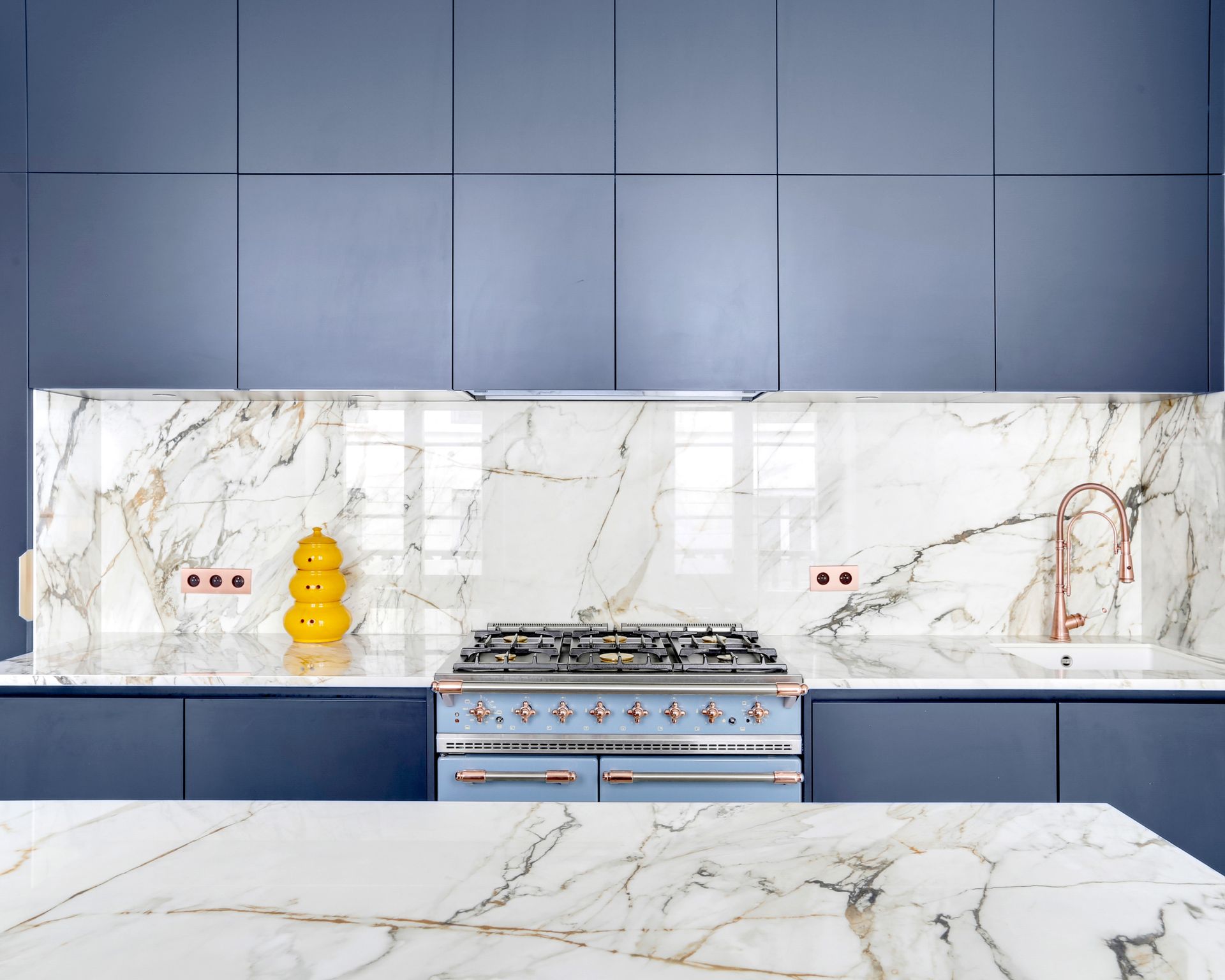 Plan de travail et crédence blancs en céramique Neolith The Size Calacatta Luxe, cuisine à façades bleues
