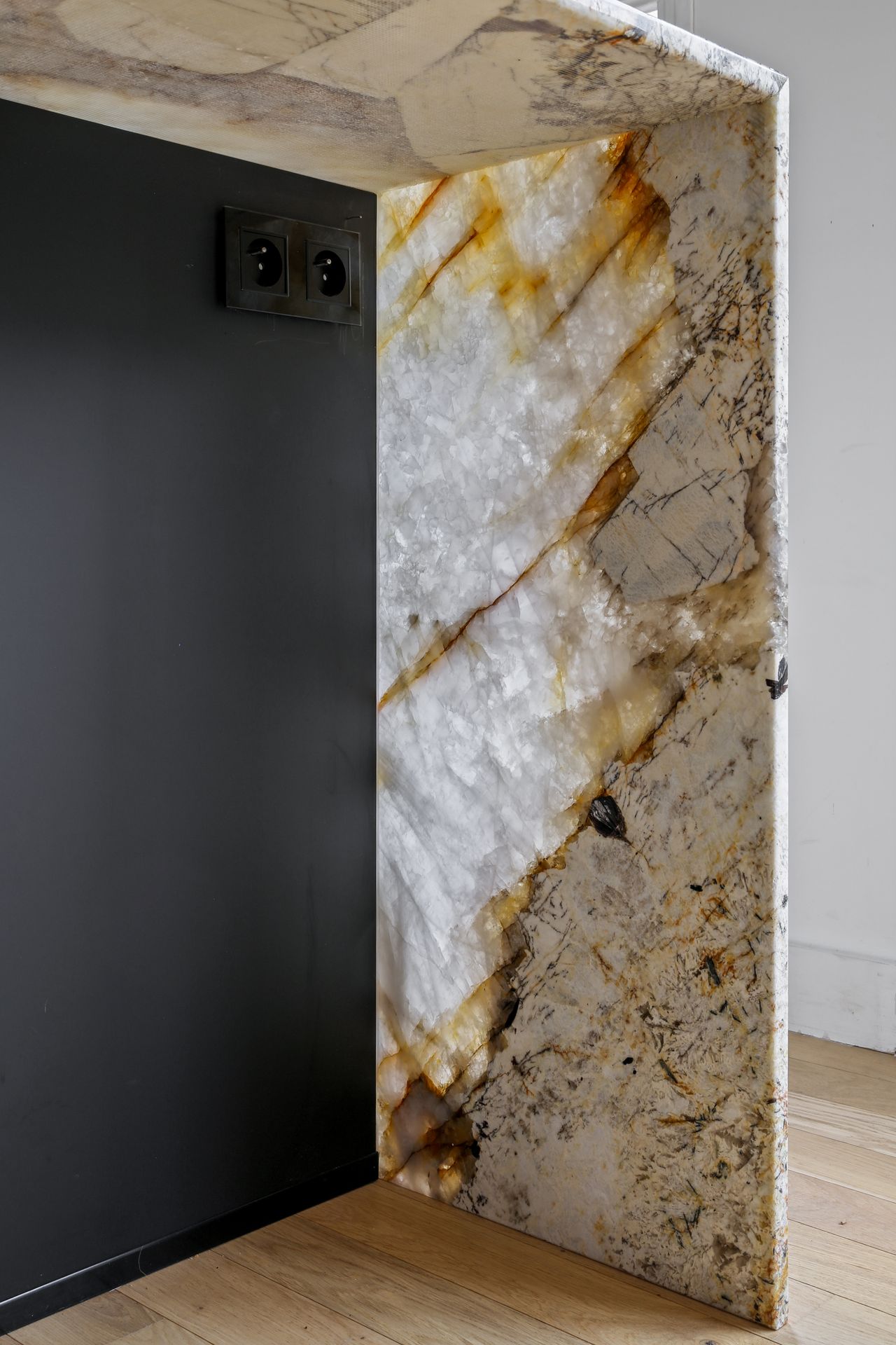 Angle d'un plan de travail blanc en quartzite Patagonia, cuisine à façades noires mates