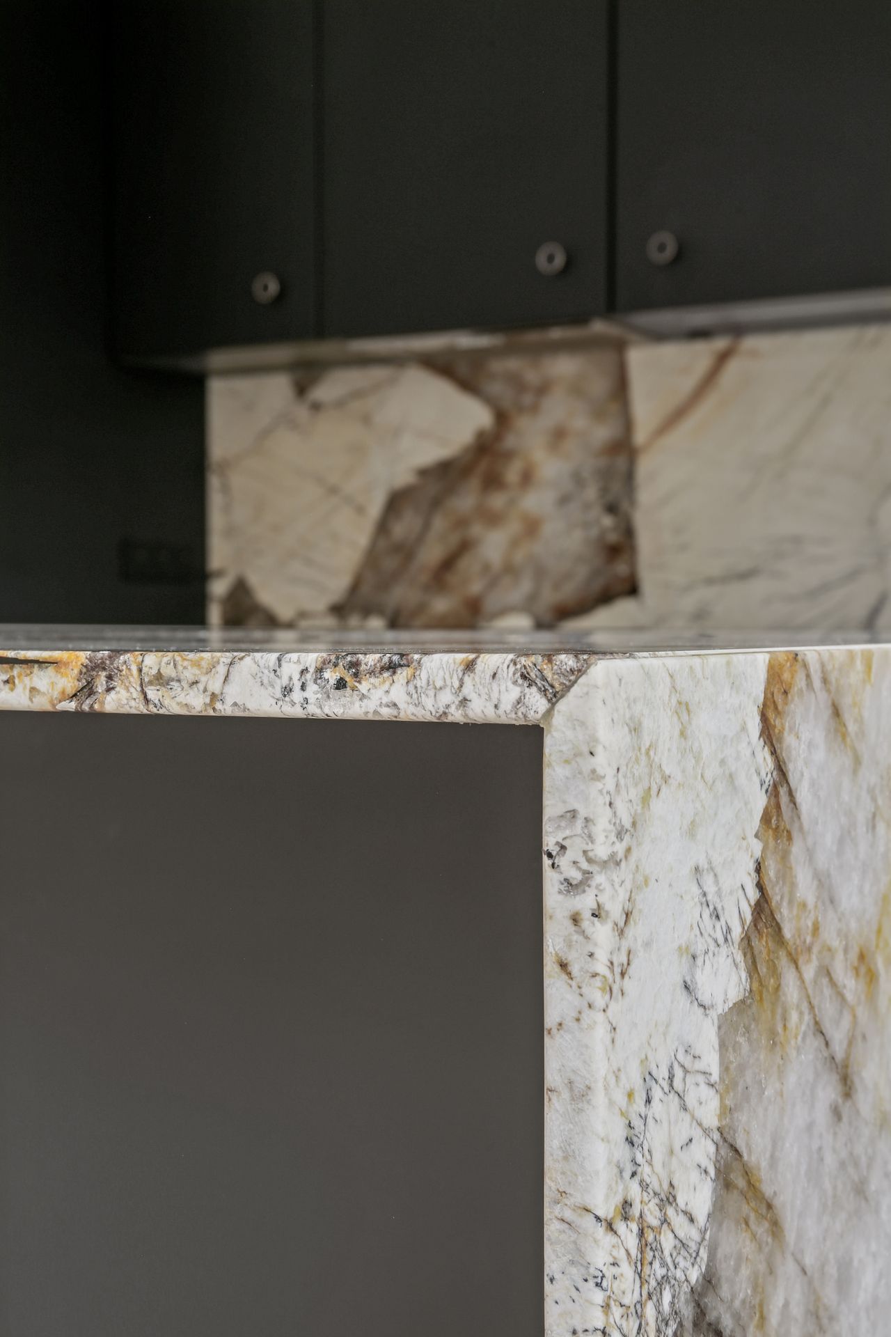 Plan de travail et crédence blancs en quartzite Patagonia, cuisine à façades noires mates