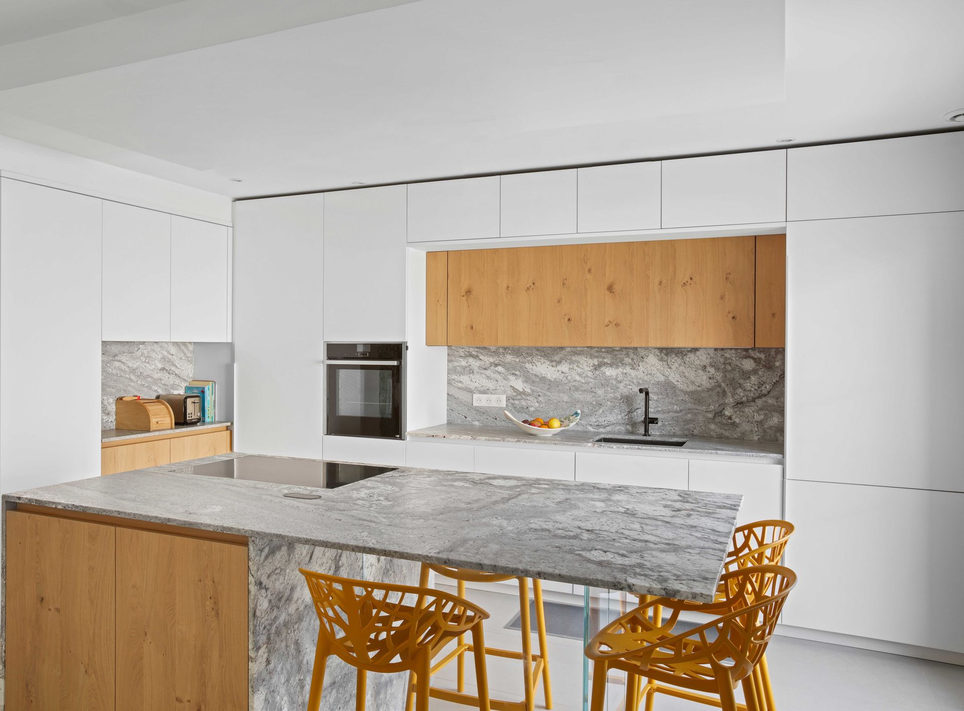 Cuisine à façades blanches et bois clair, plan de travail gris en granit Sensa Sant Angelo